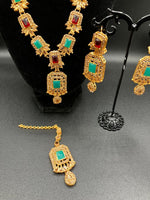 Golden jewelry set in sea green and red stones
